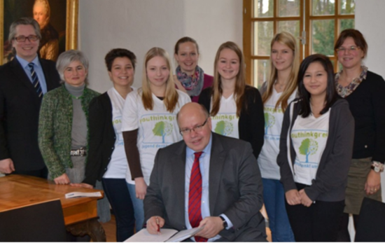 Prof. Dr. Stefan Heinemann (l.), Katy Wenning (2.v.l.), Mareike Pust, Lehrerin und Projektleiterin am MGB (5.v.l.), Dr. Martina Brick, Lehrerin und Projektleiterin am MGB (r.), Bundesumweltminister Peter Altmaier (vorne) sowie fünf Schülerinnen des Gymnasiums.